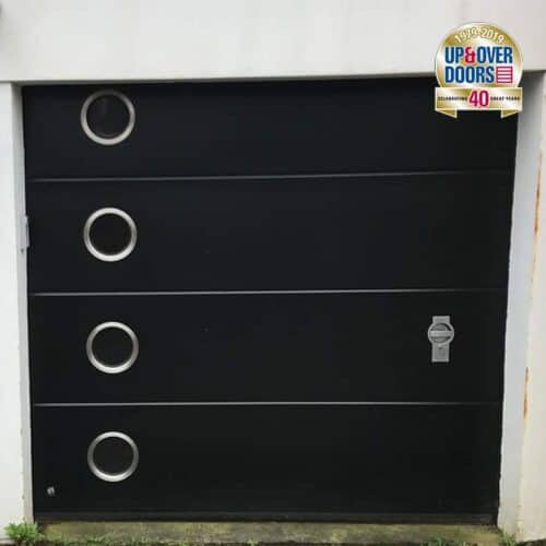 Ryterna Flush Insulated Sectional Door in Jet Black with Stainless Steel Porthole Windows and Steel Manual Locking Handle
